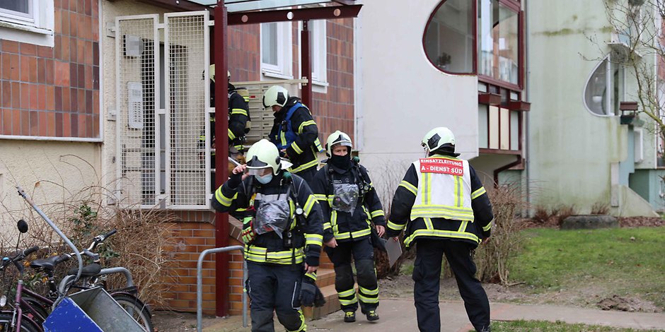 Feuerwehrleute am Eingang des Wohnhauses in Rostock.