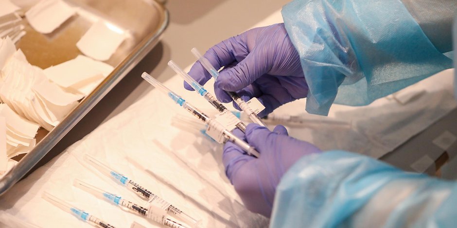 Ein Mitarbeiter des Gesundheitswesens bereitet Spritzen mit dem Corona-Impfstoff vor.