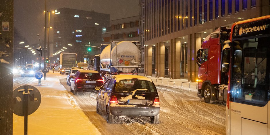 Einige Lkw in der Hamburger City kommen wegen des starken Schneefalls nicht voran. Der Verkehr gerät ins Stocken.