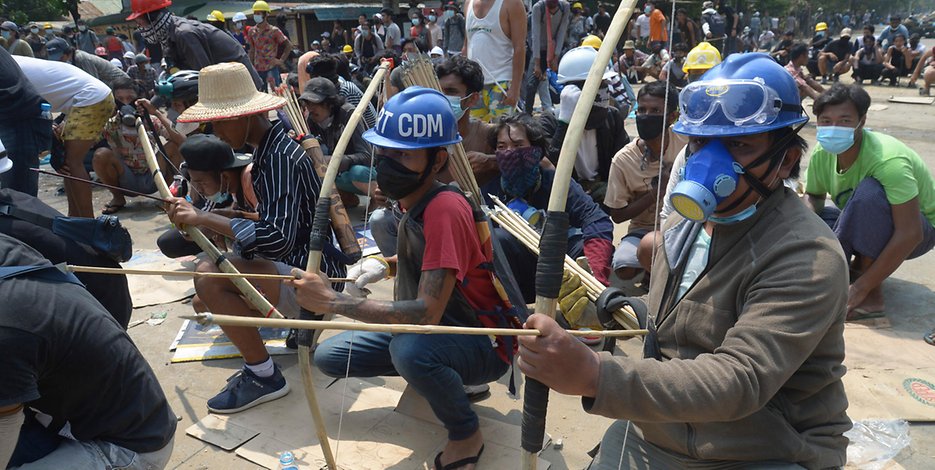 Myanmar, Yangon: Demonstranten bereiten sich mit Pfeil und Bogen auf eine Konfrontation mit der Polizei vor. 