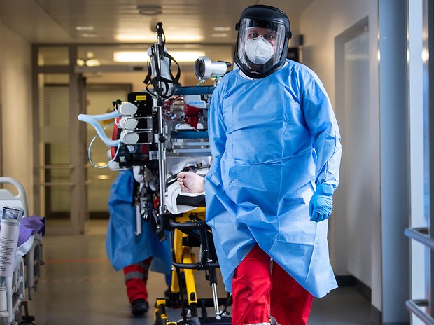 Das Team eines Intensivtransportwagens fährt auf einer Intensivstation des RKH Klinikum Ludwigsburg einen Covid-19-Patienten, der aus einem anderen Krankenhaus verlegt wurde.