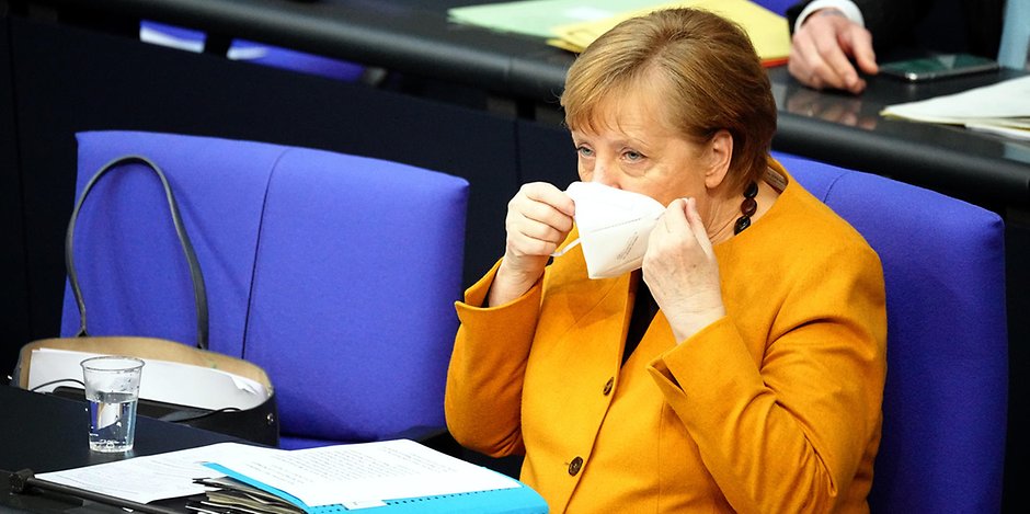 Bundeskanzlerin Angela Merkel (CDU) nimmt den Mund-Nasen-Schutz ab, bevor sie zu den Abgeordneten des Bundestags bei der Regierungsbefragung spricht.