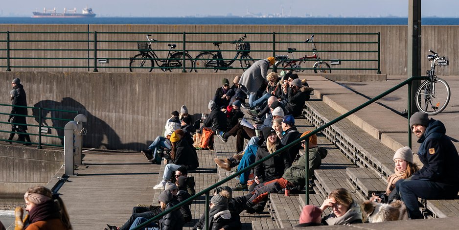 Menschen genießen das sonnige Winterwetter im Westhafen von Malmö. 