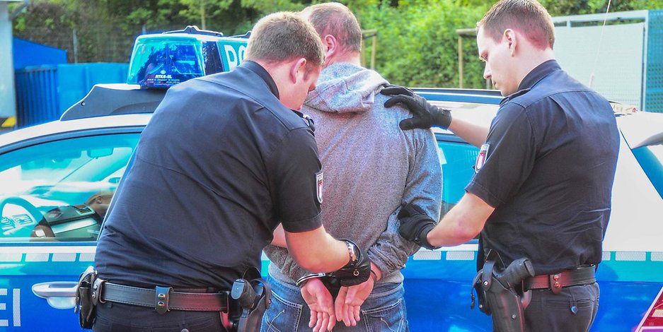 Nachdem der Autoknacker gestellt war, legten Polizisten ihm Handschellen an. (Symbolfoto)