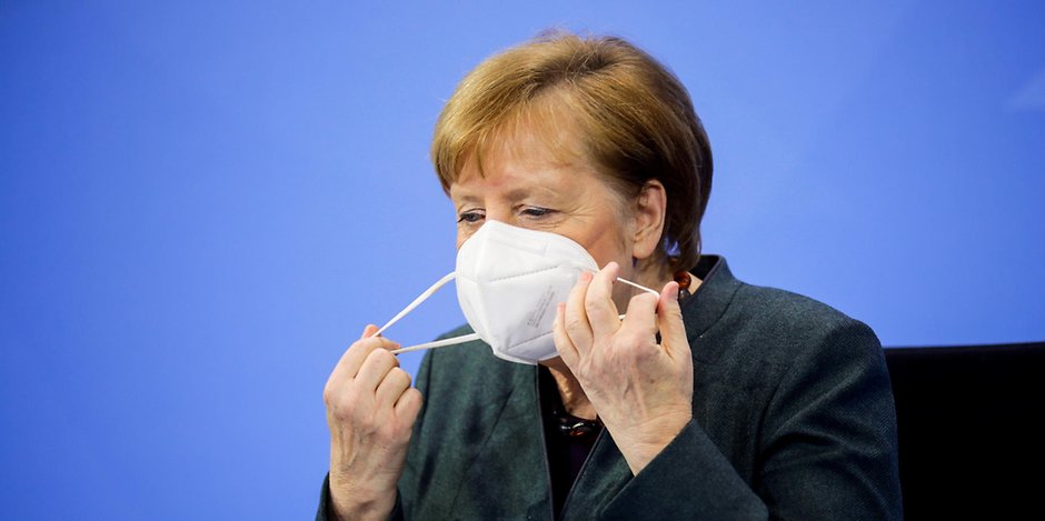 Bundeskanzlerin Angela Merkel (CDU) nimmt nach den Verhandlungen von Bund und Ländern ihre Maske ab.