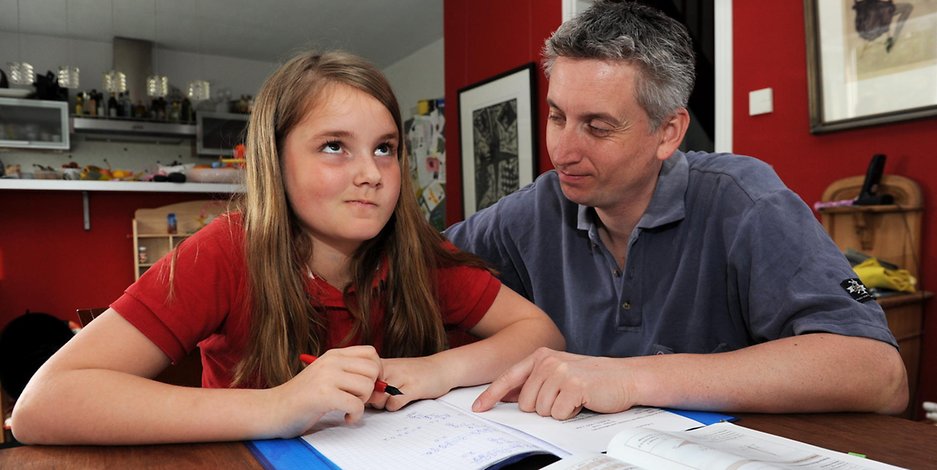 Vater und Tochter brüten über den Hausaufgaben (Symbolbild).