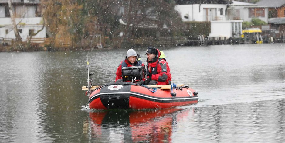 Mit einem Schlauchboot und einem eingebauten Sonar durchsucht die Polizei den Teich in Hamburg.