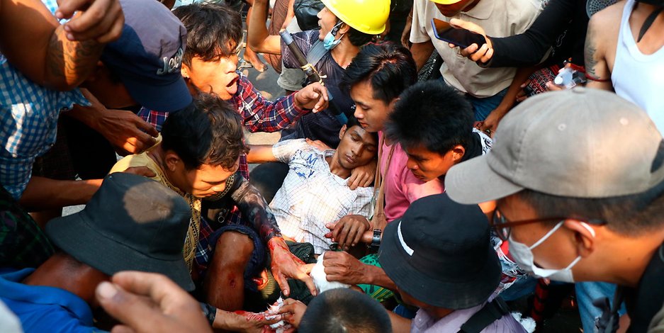 Demonstranten versorgen einen Verletzen in Yangon.