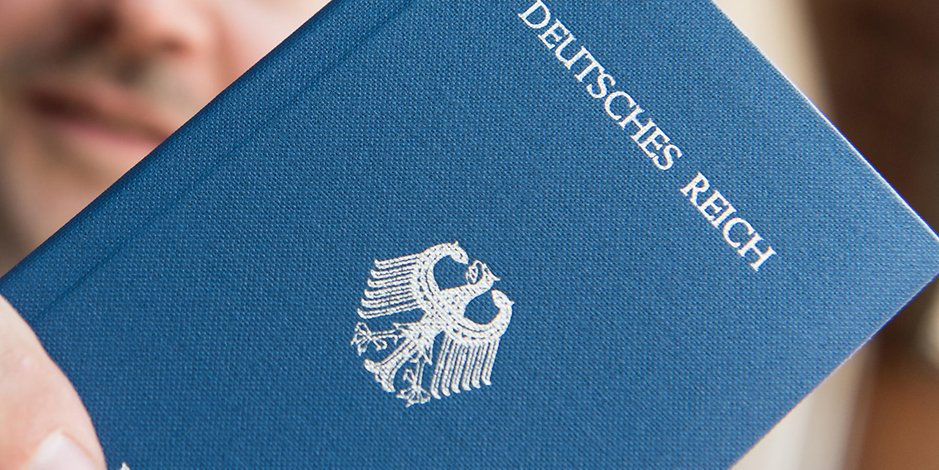 Ein Mann hält ein Heft mit dem Aufdruck „Deutsches Reich Reisepass“ in der Hand. Die Zahl der in Hamburg erfassten Reichsbürger ist laut Landesamt für Verfassungsschutz gestiegen. (Archivfoto)