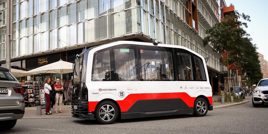 Der autonom fahrende Kleinbus HEAT ist bei einer ersten Testfahrt in der Hafencity unterwegs und hält an einer Bushaltestelle. 
