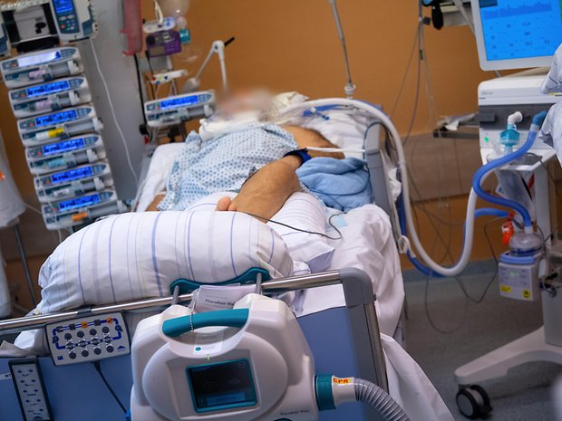 Ein Covid-19 Patient liegt in einem isoliertem Intensivbett-Zimmer. Mittlerweile gibt es hunderte von ihnen in Deutschland.