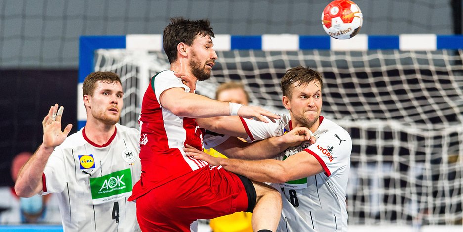 Die deutschen Handballer Johannes Golla und Fabian Böhm werfen sich im Spiel gegen Ungarn in einen Angriff.