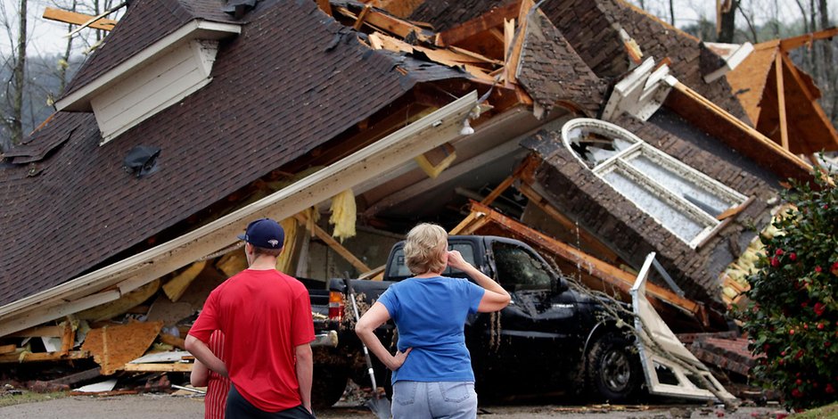 USA, Birmingham: Anwohner stehen vor einem eingestürzten Haus. 
