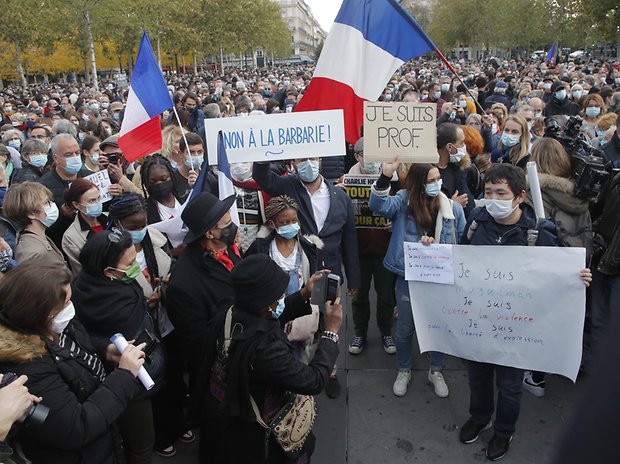 Menschen versammeln sich auf dem Platz der Republik mit Plakaten mit den Aufschriften „Nein zur Barbarei
