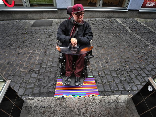 Rollstuhlfahrer Julian Wendel vor einer der Rampen aus Legosteinen.