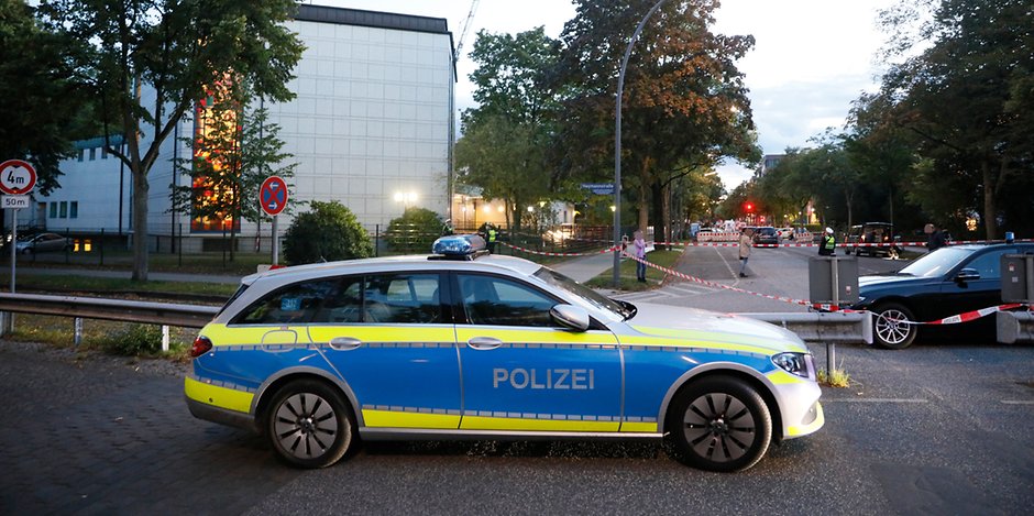 Einsatzkräfte und Polizeiautos stehen am Sonntagabend vor der Synagoge in Hamburg. Hier wurde am Nachmittag ein jüdischer Student angegriffen.