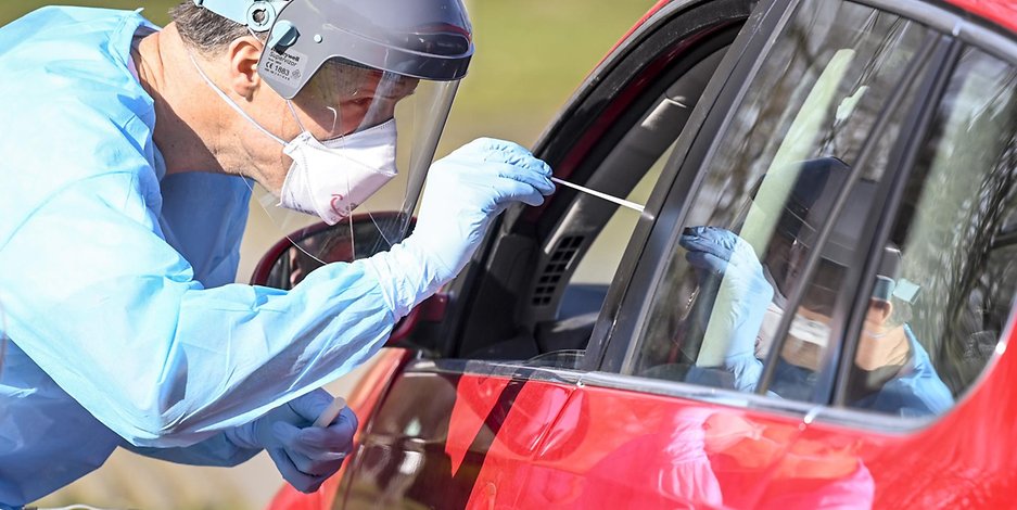 Ein Arzt nimmt einen Abstrich an einer Drive-in-Teststation in Schleswig-Holstein (Symbolfoto).