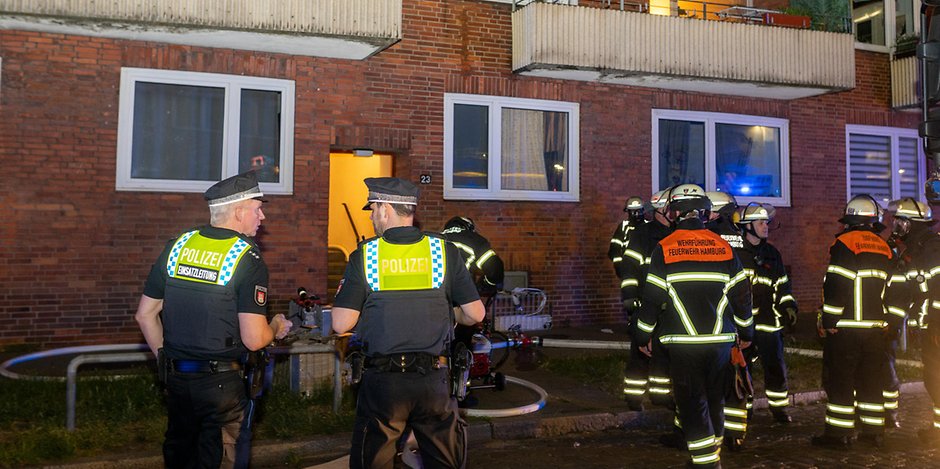 Polizei- und Feuerwehrkräfte vor dem Wohnhaus in Hamburg.