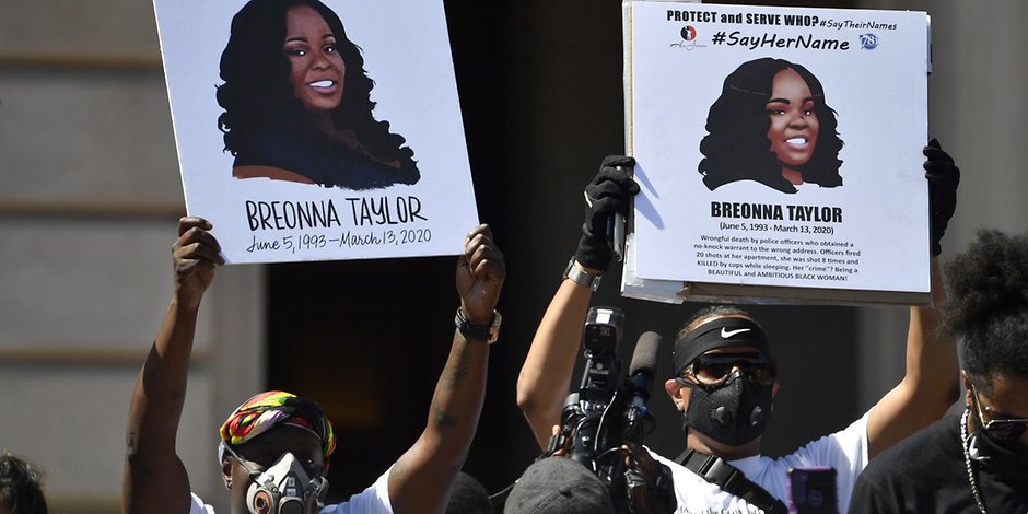 Schilder zeigen Breonna Taylor während einer Kundgebung zu ihren Ehren.