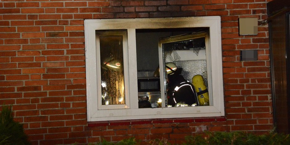 Ein Feuerwehrmann löscht im Inneren der Wohnung.