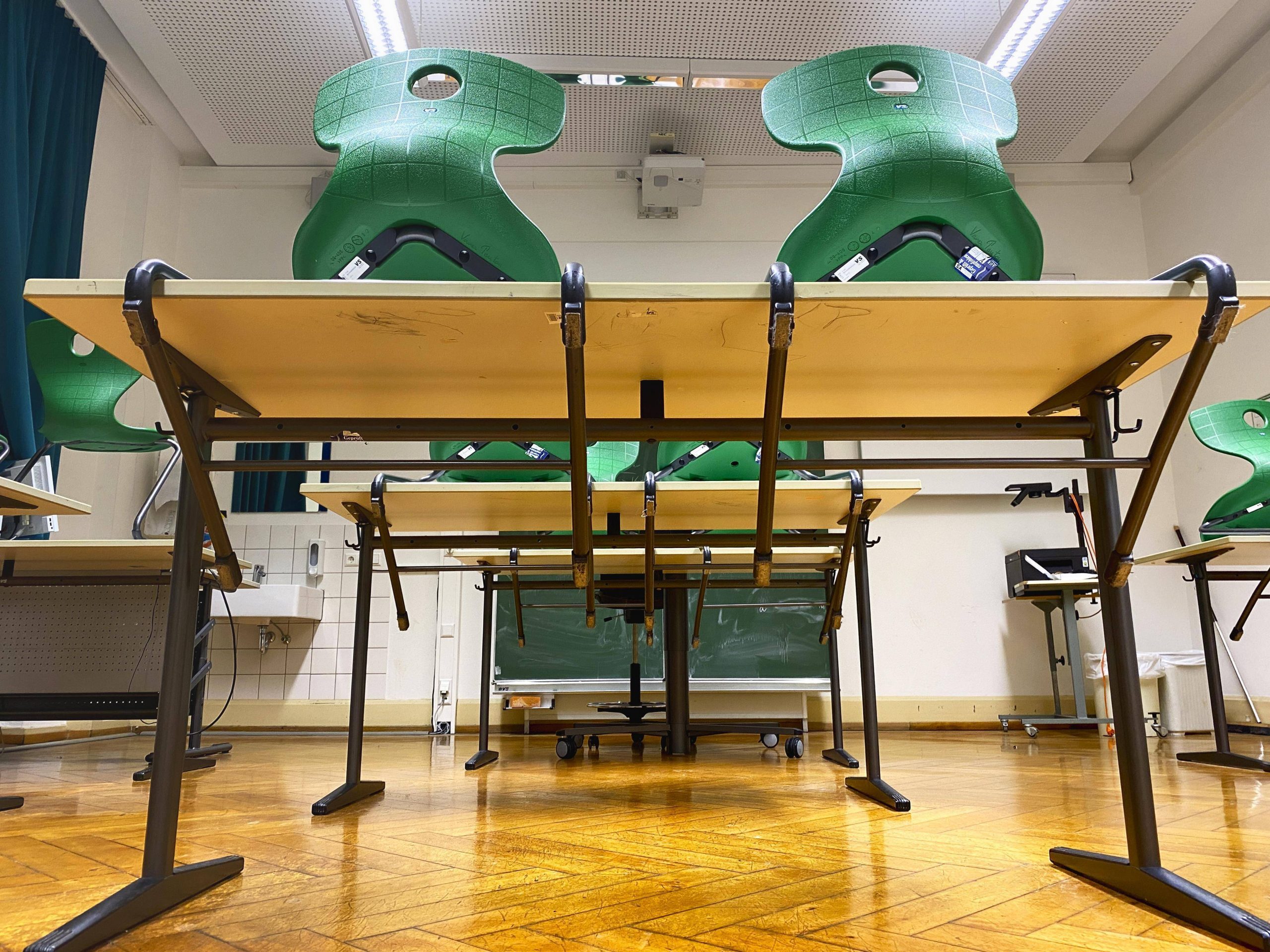 Auf Tische gestellte Stühle in einem Klassenraum