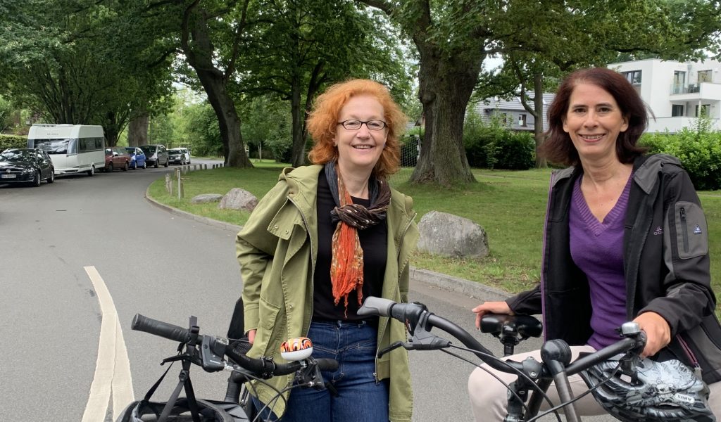 Karin Ros und Katrin Hofmann mit Fahrrädern auf einer Straße