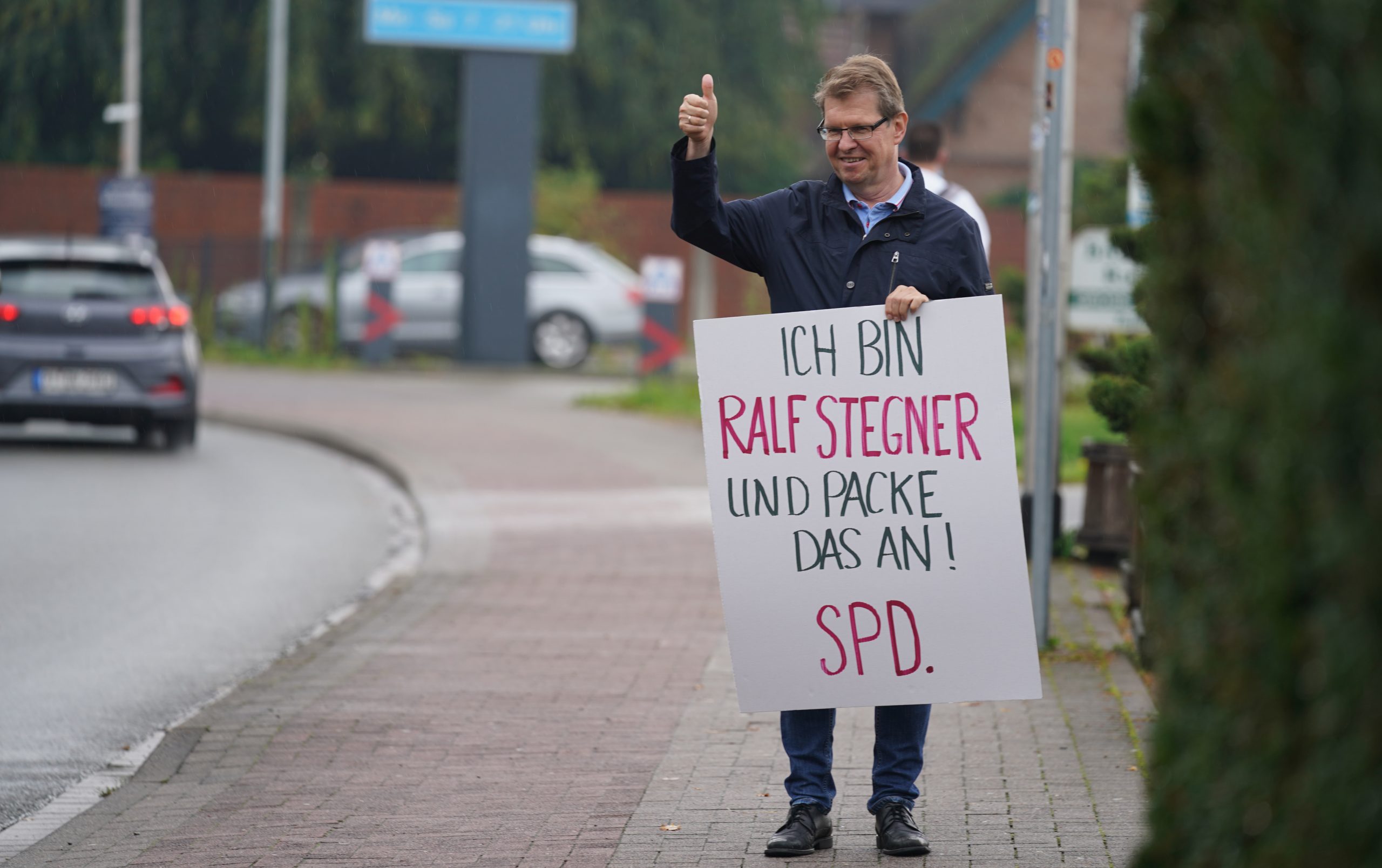 SPD-Politiker hält Wahlplakat in der Hand