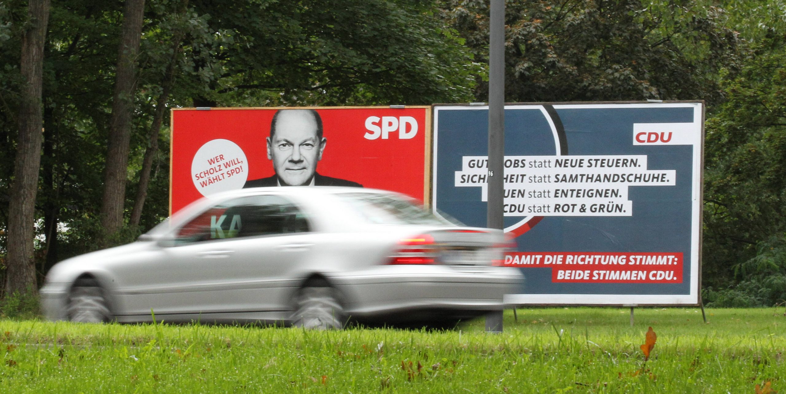 Ein Wahlplakat der SPD mit dem Konterfei von Kanzlerkandidat Olaf Scholz steht neben einem Wahlplakat der CDU an einer Straße in Barmbek.