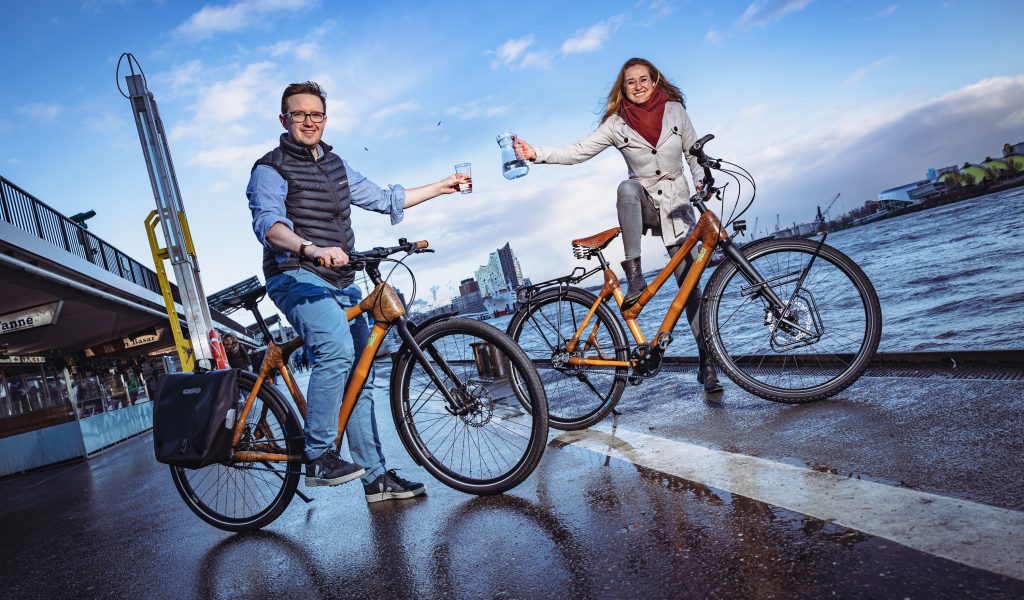 Mit Bambus-Rädern unterwegs: „Viva con Agua“-Geschäftsführerin Carolin Stüdemann und Maximilian Schay von „my Boo“.