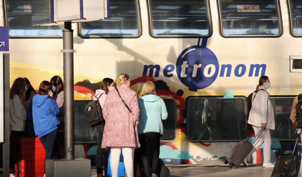 Menschen am Bahnhof vor einem Metronom