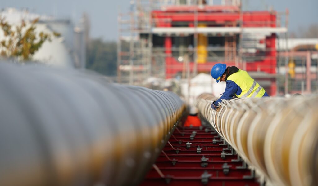 Arbeiter bauen Gas-Pipelines für den geplanten LNG-Flüssiggas-Schwimmterminal zusammen.