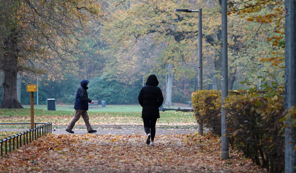 Zwei Spaziergänger laufen durch den Hamburger Volkspark. (Symbolbild)