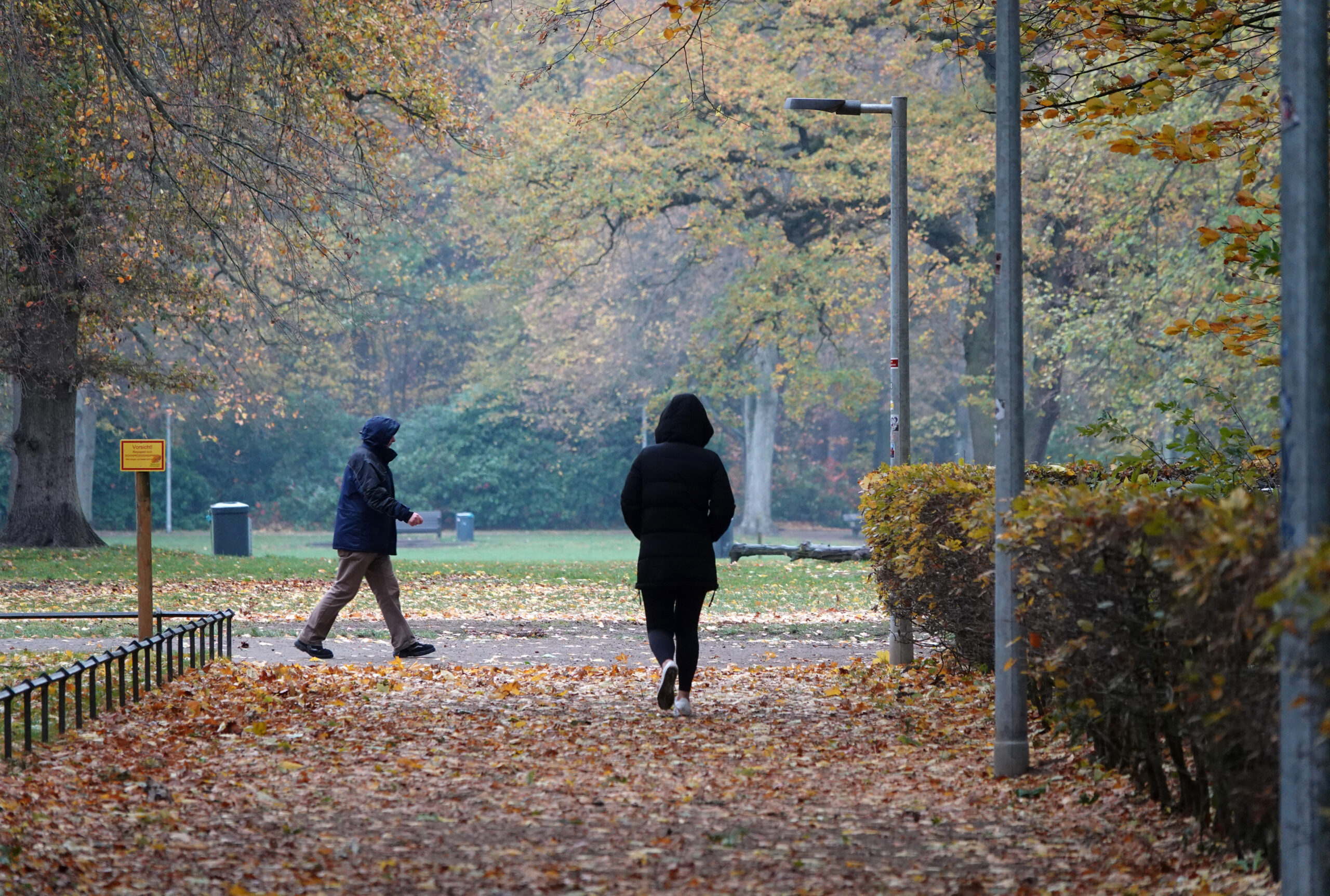 Zwei Spaziergänger laufen durch den Hamburger Volkspark. (Symbolbild)