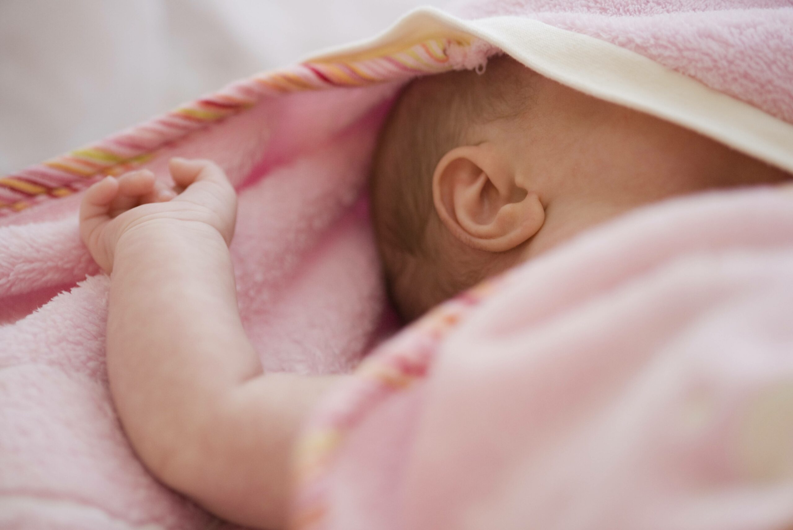 Schlafendes Baby unter einer rosafarbenen Decke