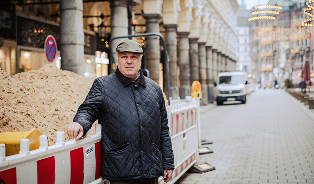Hoteldirektor Niklaus Kaiser von Rosenburg steht vor dem Baustellenlager für den Jungfernstieg – mitten in den Colonnaden.