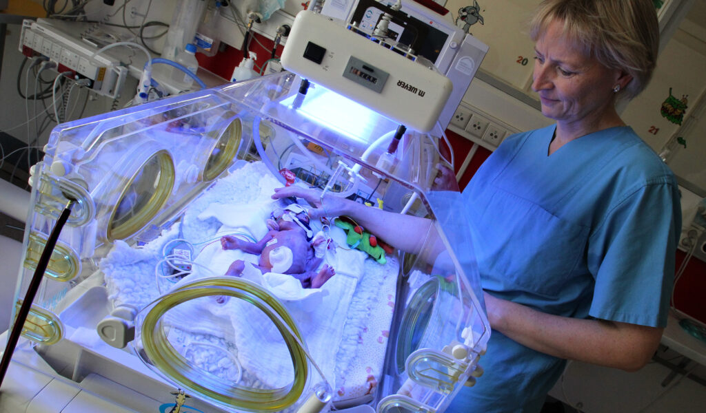 Auf der Pädiatrischen Intensivstation des Dietrich-Bonhoeffer-Klinikums in Neubrandenburg versorgt eine Krankenschwester ein Frühchen im Inkubator. (Archivbild)