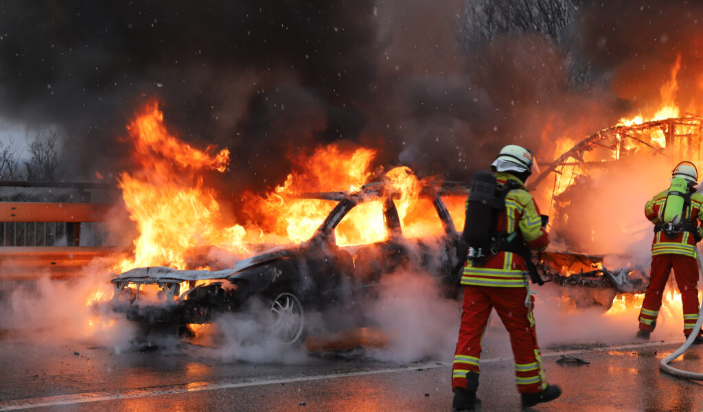 Feuerwehrkräfte bekämpfen die Flammen auf der A23. Wohnwagen und Auto wurden komplett zerstört.