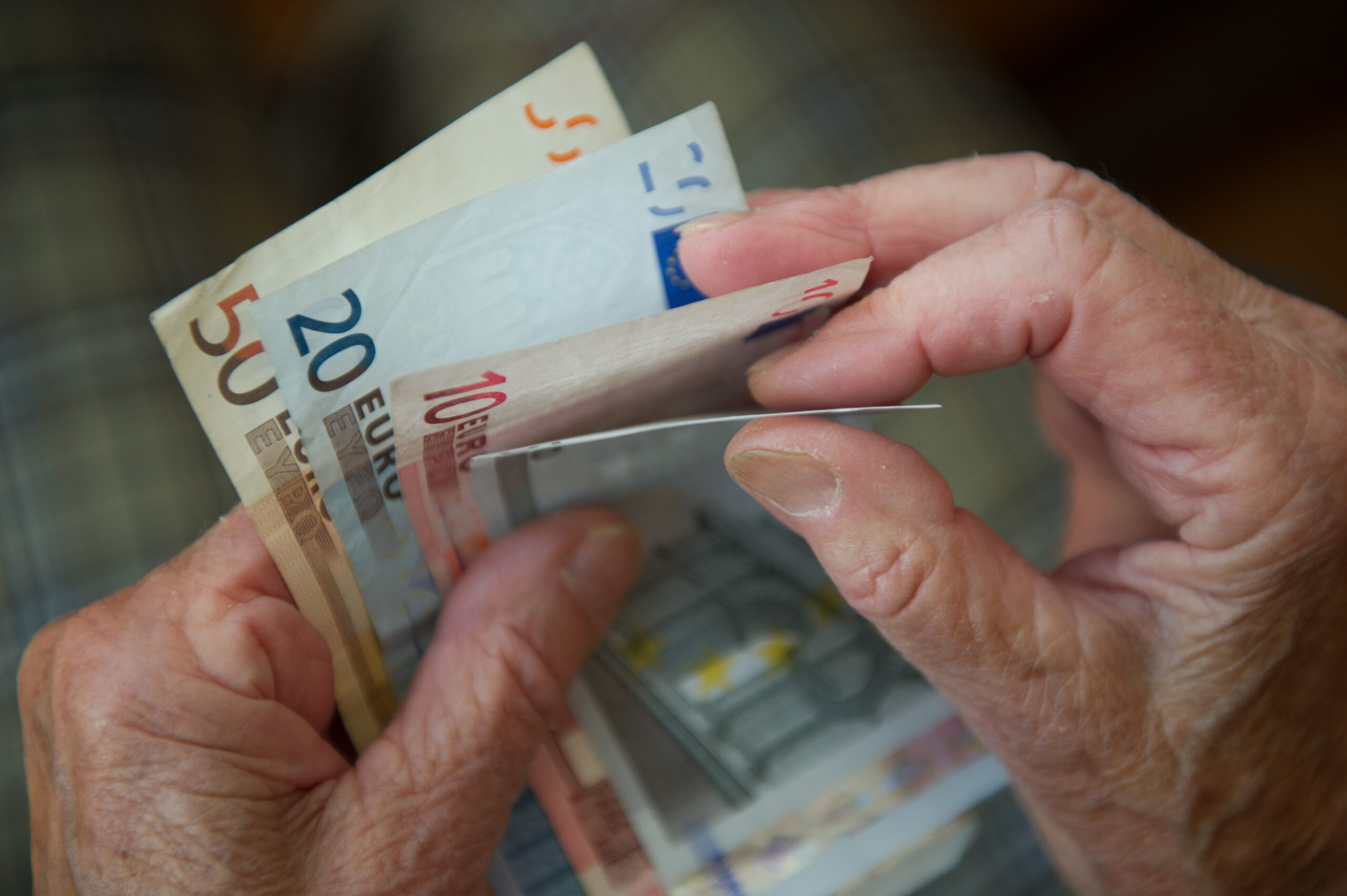 Rentner hält Geld in der Hand