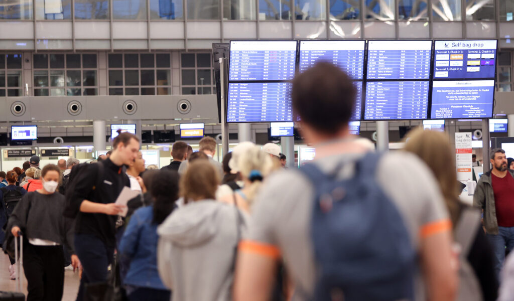 Zahlreiche Reisende stehen am Morgen in einer Schlange im Terminal 1 an, die zur Sicherheitskontrolle am Hamburger Flughafen führt. (Archivbild)