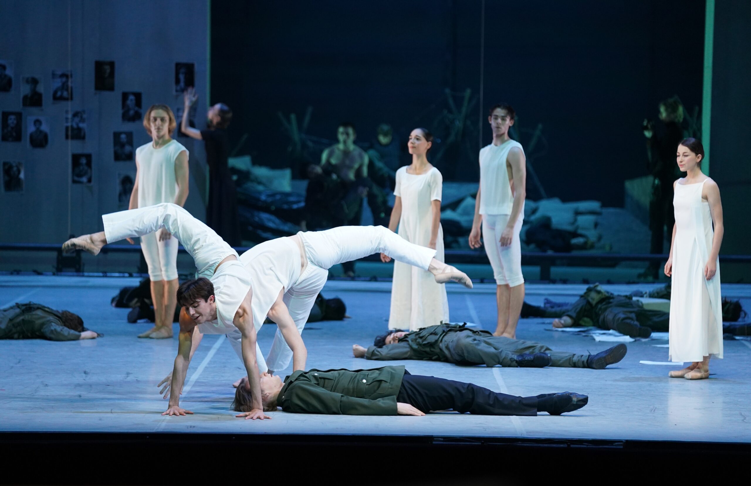 Balletttänzer in weiß tanzen auf der Bühne. Unter ihnen liegen Soldaten