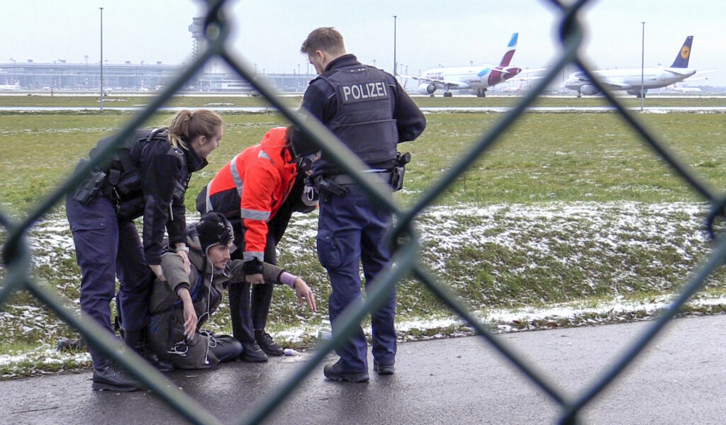Polizisten und ein Klima-Aktivist am Donnerstag auf dem BER-Flughafen