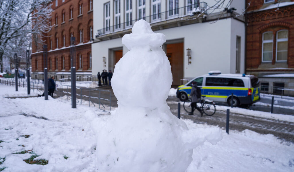Ein Schneemann steht auf einer schneebedeckten Wiese vor dem Kieler Landeshaus.