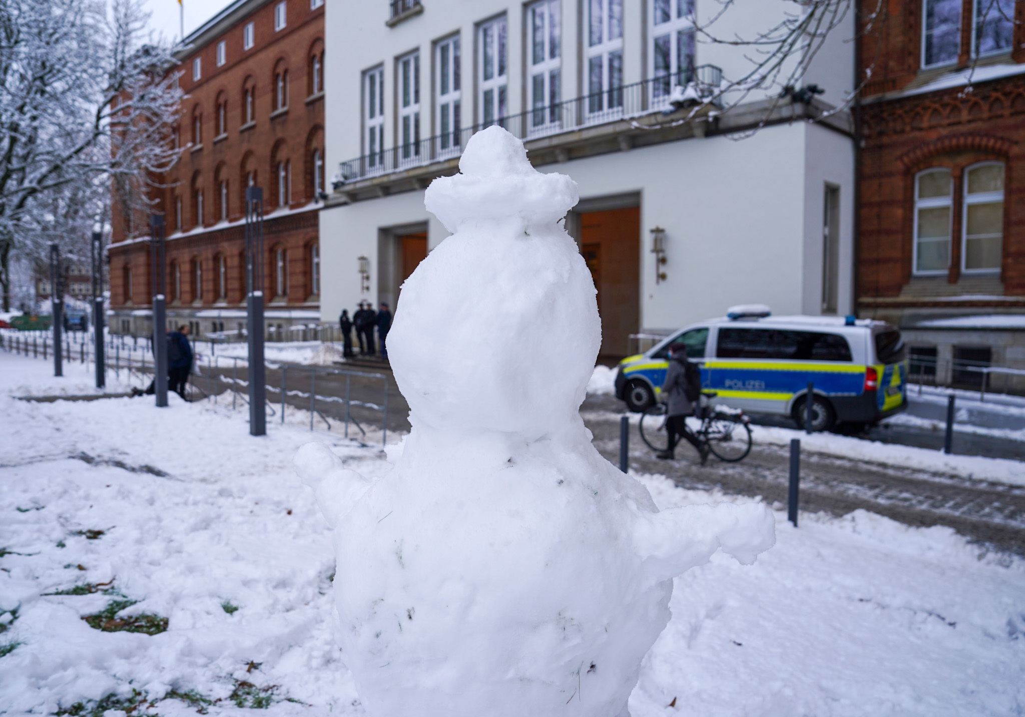 Ein Schneemann steht auf einer schneebedeckten Wiese vor dem Kieler Landeshaus.