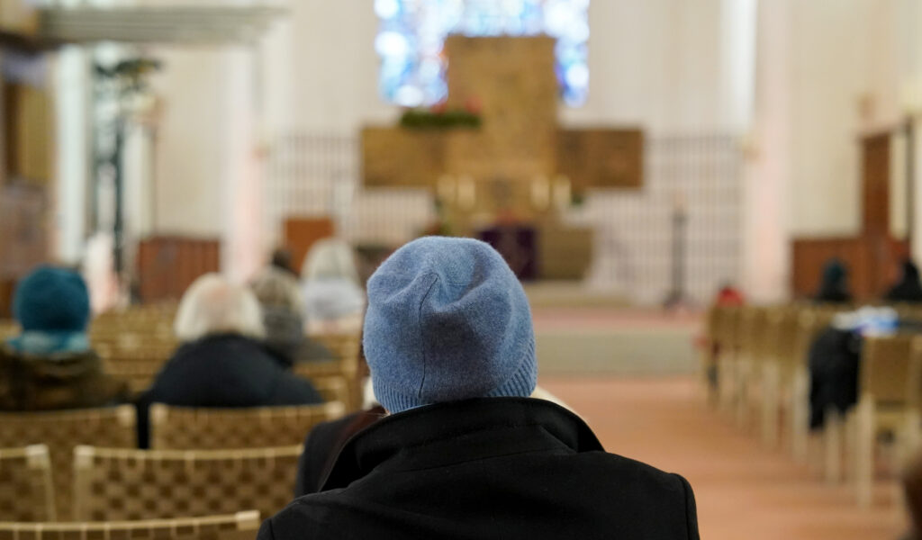 Frau mit Mütze in Kirche