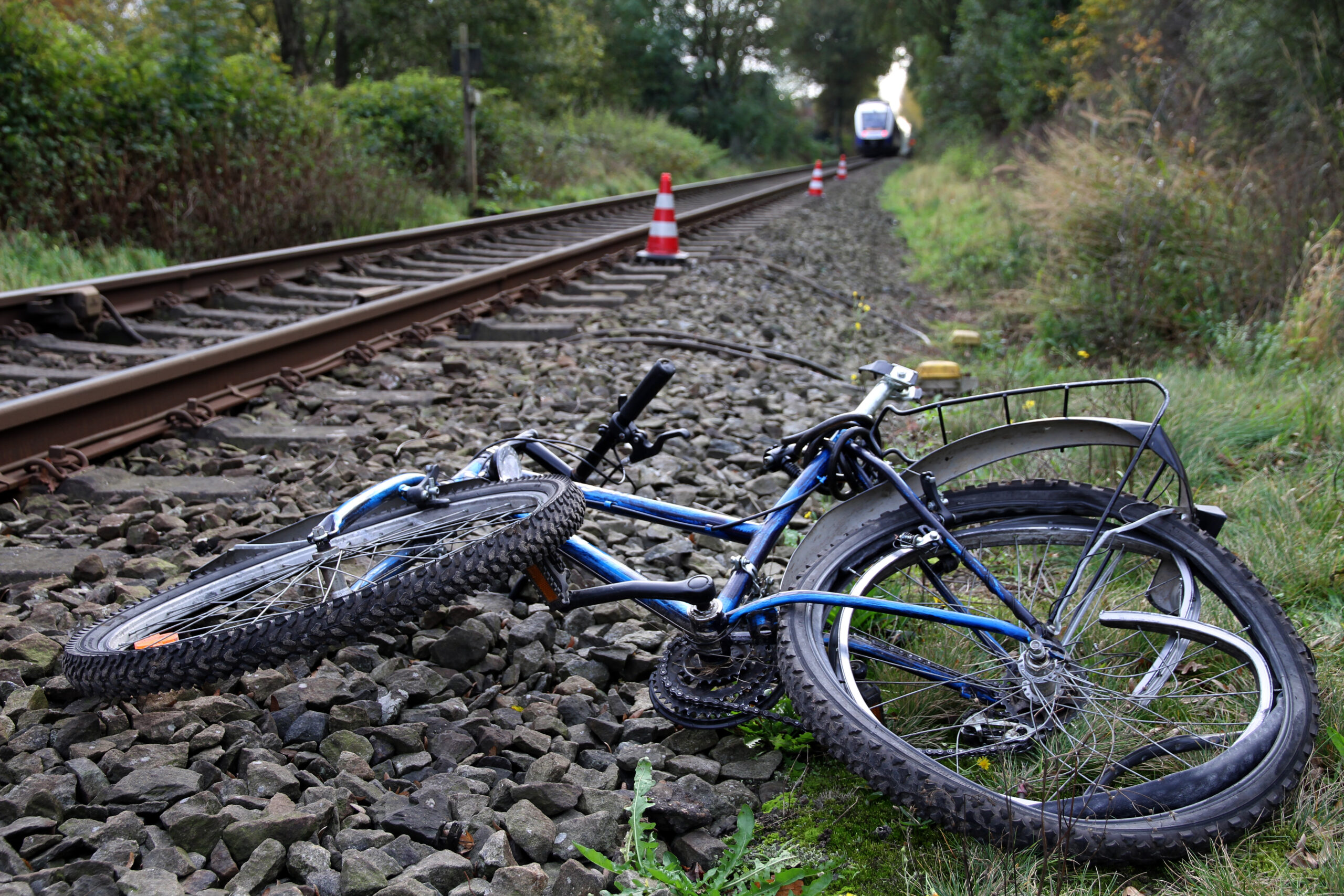 Ein völlig demoliertes Fahrrad liegt neben einem Bahngleis