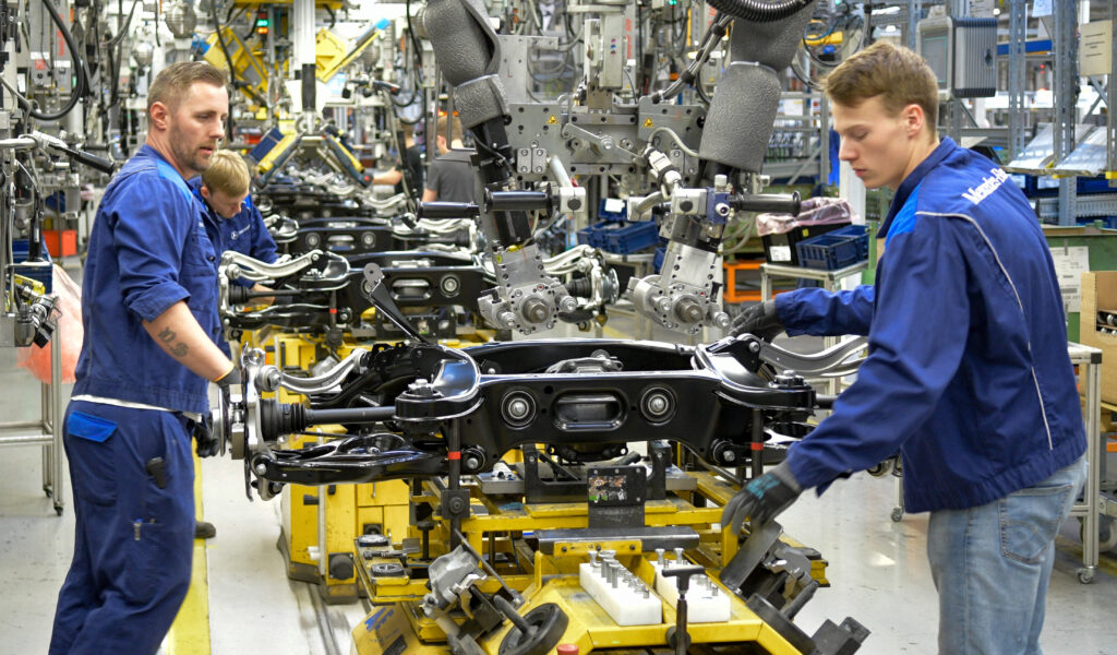 Techniker montieren im Hamburger Mercedes-Benz-Werk Fahrzeugachsen.