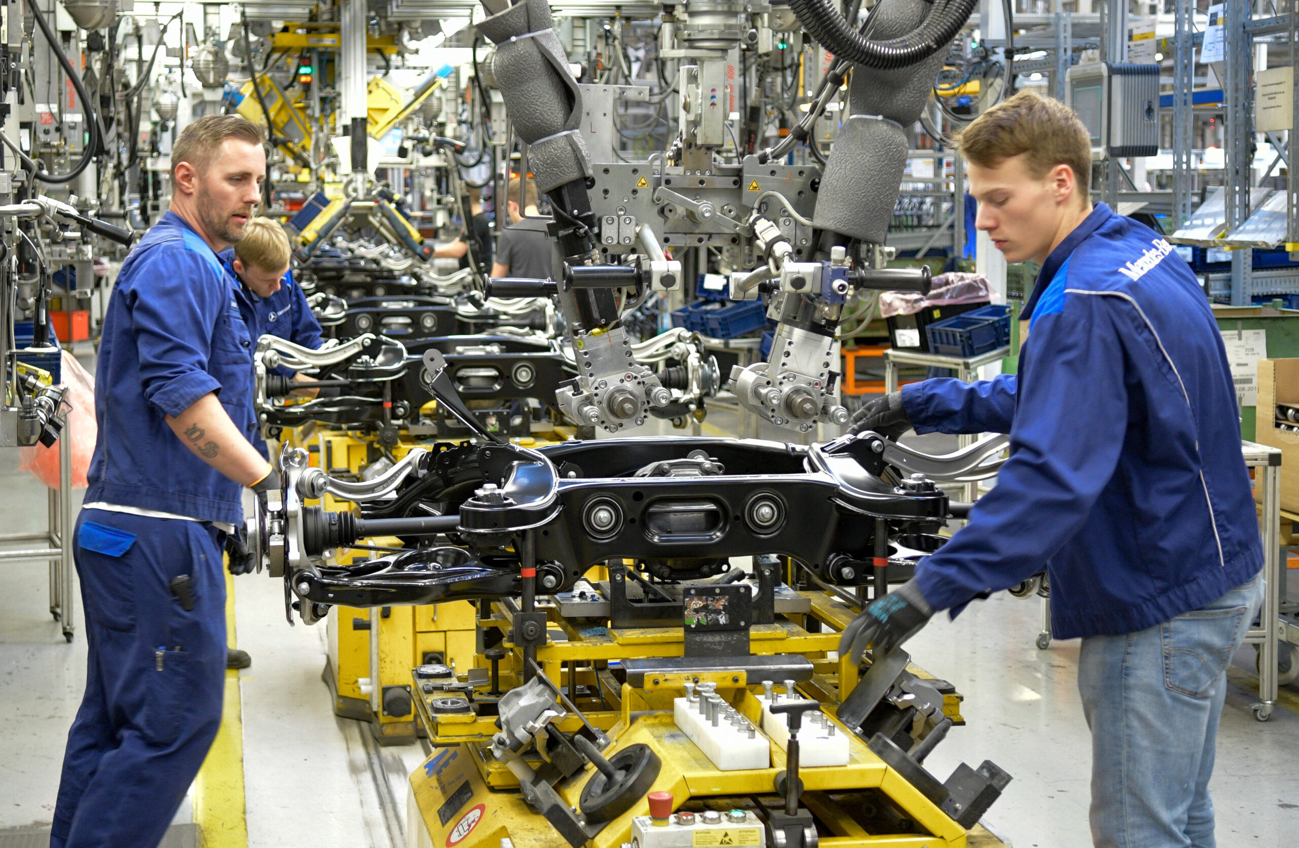 Techniker montieren im Hamburger Mercedes-Benz-Werk Fahrzeugachsen.