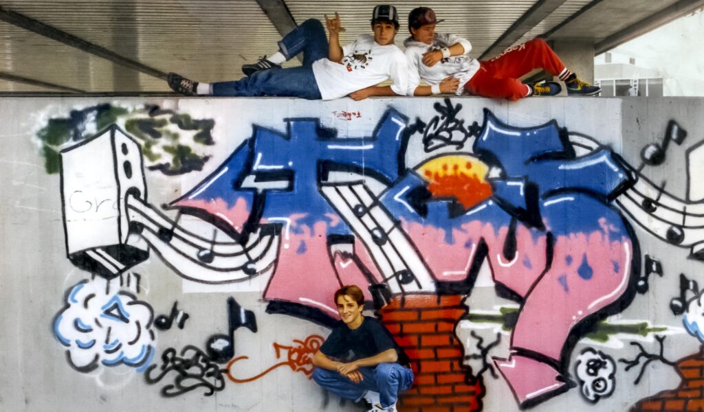 Drei junge Sprayer posieren vor ihrem Piece