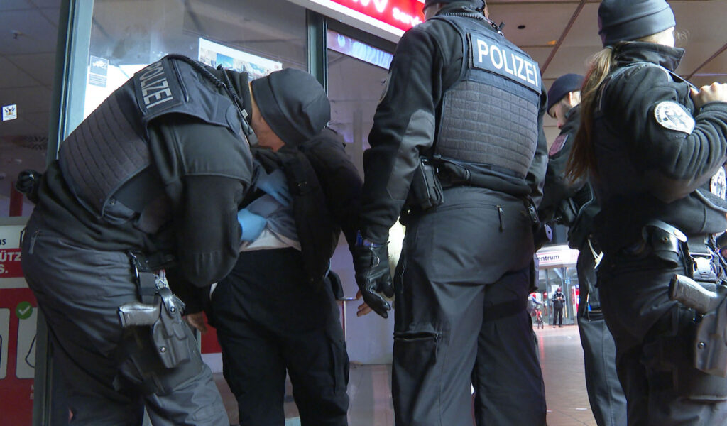 Polizisten kontrollieren am Hamburger Hauptbahnhof einen Mann.