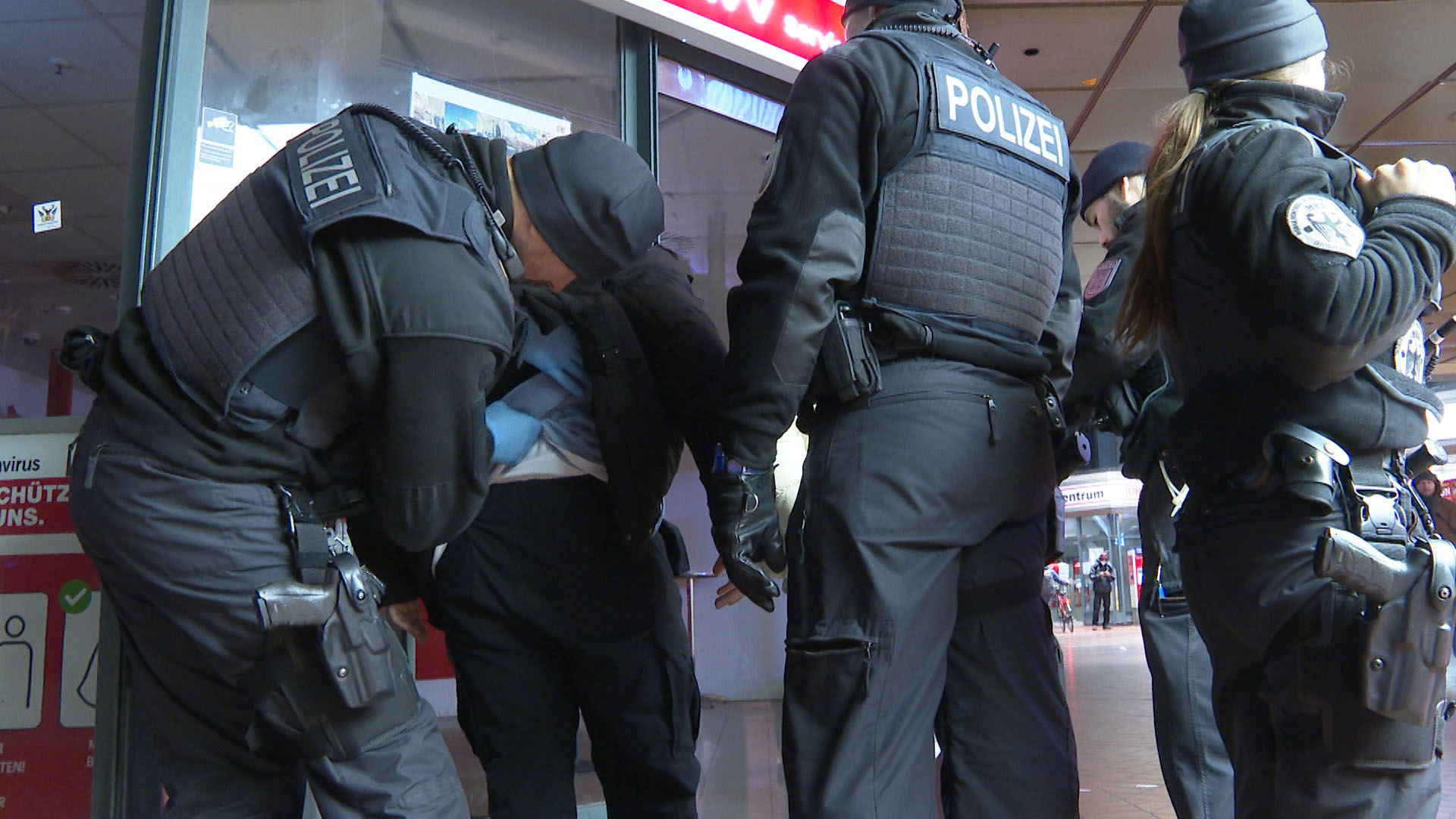 Polizisten kontrollieren am Hamburger Hauptbahnhof einen Mann.